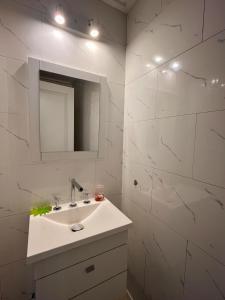 a white bathroom with a sink and a mirror at Tandil Centro vistas in Tandil +14 photos