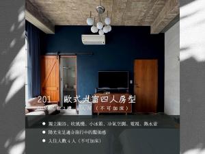 Habitación con pared azul y TV. en 太古Taikoo home, en Tainan