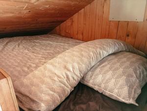 a bed with a pillow in a room at Cozy Cabin near Balka Beach with outdoor toilet and kitchen in Neksø
