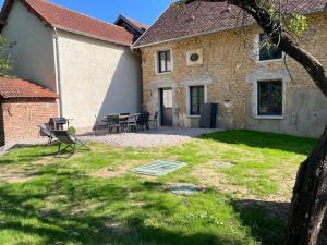 una casa con una mesa y sillas en el patio en La Maison des Lacs et des Parcs, en Amance
