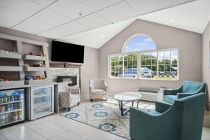 a living room with a fireplace and a tv at Sonesta Essential Hotel Blue Springs in Blue Springs