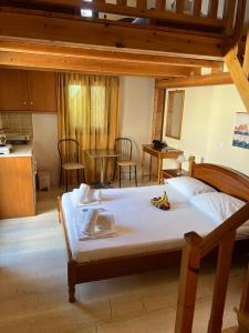 a bedroom with a large bed and a kitchen at Santa Magia in Kamari