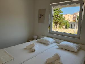 a pair of beds in a room with a window at Ventana Pool Apartments - Stara Novalja in Stara Novalja +23 photos