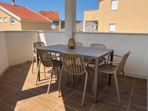 a blue table and chairs on a balcony at Ventana Pool Apartments - Stara Novalja in Stara Novalja