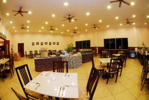 a dining room with tables and chairs and ceiling fans at Celyn Resort Kinabalu in Kampong Kundassan