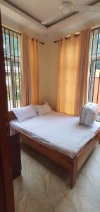 a large bed in a room with windows at Hopeland Villas in Msaranga