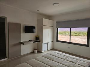 a bedroom with a bed and a large window at Hotel Cuesta de Miranda in Villa Unión