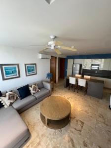 a living room with a couch and a table at Penthouse en ubicación principal con terraza privada y todas las amenidades en la propiedad, en el corazón de Playa del Carmen in Playa del Carmen