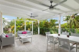 Elle comprend une terrasse dotée d'un mobilier blanc et d'un ventilateur de plafond. dans l'établissement Cassia Heights 29 Royal Westmoreland, à Saint James