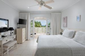 une chambre blanche avec un lit et un balcon dans l'établissement Cassia Heights 29 Royal Westmoreland, à Saint James 1 autre photo
