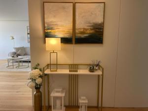 a table with a lamp and a painting on the wall at LUX BeACH in Praia da Barra