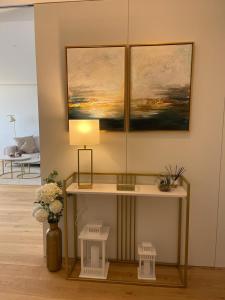 a table with a lamp and a painting on the wall at LUX BeACH in Praia da Barra