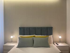 ein Schlafzimmer mit einem Bett mit blauem Kopfteil und zwei Lampen in der Unterkunft LUX BeACH in Praia da Barra