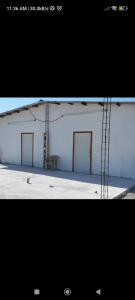 a picture of a white building with red doors at Casa Arame in Cedro