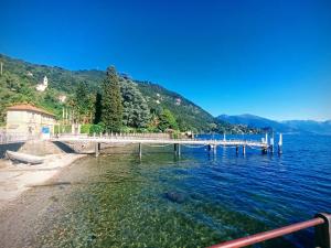 a dock on a lake with mountains in the background at Portico sul lago in Oliveto Lario