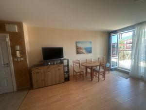een woonkamer met een eettafel en een televisie bij Amartmán přímo u moře - Elenite až 5 osob in Sveti Vlas