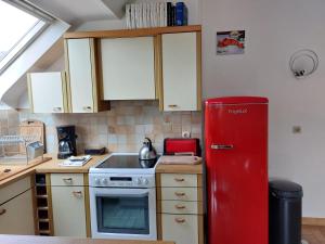 a kitchen with an old red refrigerator in a kitchen at Maison de village au Linkin in Perros-Guirec