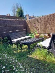 a picnic table and two benches in a garden at Maison de village au Linkin in Perros-Guirec