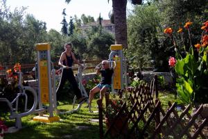 a woman and a child playing on a playground at olivensun apartment 3 in Gythio +2 photos
