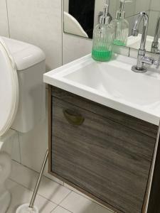 a bathroom with a sink and a toilet at Apartamento em Guarapuava in Guarapuava