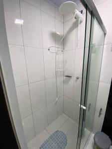 a shower with a glass door in a bathroom at Estúdio Moderno em frente à Rodoviária in Guarapuava +33 photos