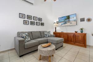 Una sala de estar con un sofá y un televisor. en 2-bd Condo With Pool, Walk To Beach, en Coco