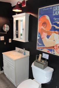 a bathroom with a white toilet and a poster at Lake Huron Lady of the Lake Cabin w HotTub, Sauna in Greenbush +39 photos