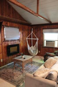 a living room with a couch and a hammock at Lake Huron Lady of the Lake Cabin w HotTub, Sauna in Greenbush