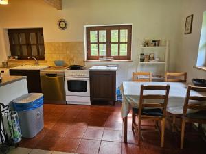 a kitchen with a table and a stove top oven at Kaszuby Cottage in Sulęczyno