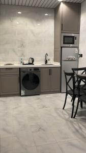 a kitchen with a stove and a sink and a dishwasher at dana hotel apartments in Taif