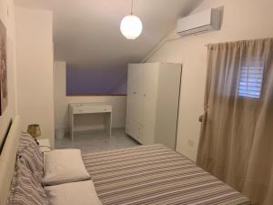 a small bedroom with a bed and a refrigerator at La Pigna in Marina di Sorso