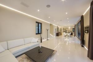 a living room with a white couch and a table at Stunning Seafront House In Istria Villa Vrsar Magnifique Contemporary 5 Bedroom Villa Sauna And Gym Direct Access To Sea in Vrsar