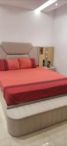 a bedroom with a large bed with red sheets at Villa au centre ville Rabat in Rabat