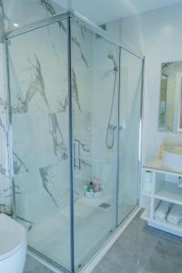 a bathroom with a glass shower with a toilet and a sink at Pousadas CAMINO de FINISTERRE in Mazaricos