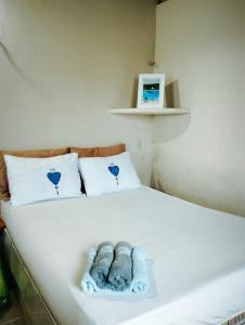 a white bed with two stuffed animals on it at Aconchego Balbino 2 in Cascavel