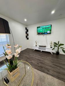 a living room with a flat screen tv on the wall at 3 STATE FAIR l DT Dallas l FIFA READY l Staycation 1Bd1Ba in Dallas +4 photos