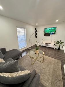 a living room with a couch and a tv at 3 STATE FAIR l DT Dallas l FIFA READY l Staycation 1Bd1Ba in Dallas