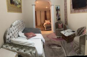 una sala de estar con un sofá y una silla en Aeroport Rooms, en Chişinău