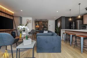 een woonkamer met een blauwe bank en een keuken bij Life 801 - Exclusive & Bright Apt/pool/gym/balcony in El Poblado