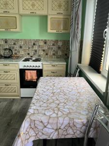a kitchen with a table and a stove at Аренда квартир Балхаш 1ком in Balqash