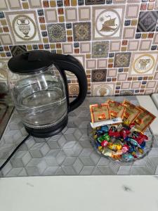 a vase sitting on a table with a plate of candy at Аренда квартир Балхаш 1ком in Balqash