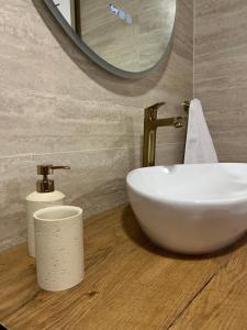a bathroom with a white sink and a mirror at Apartman D11 in Ljubuški +24 photos