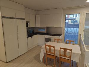 a kitchen and dining room with a table and chairs at Nice 74,5 m2 app wih 4 beds and sauna in Espoo
