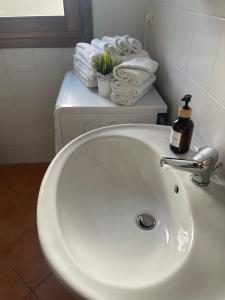 La salle de bains est pourvue d'un lavabo blanc et de serviettes. dans l'établissement Design apartments - P, à Siniscola 23 autres photos