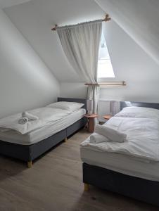 two beds in a room with a window at City und Natur - Ferienwohnung an der Itz in Coburg