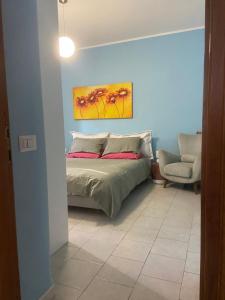 a bedroom with a bed with a painting on the wall at La Casa del Borgo Antico in Campoverde