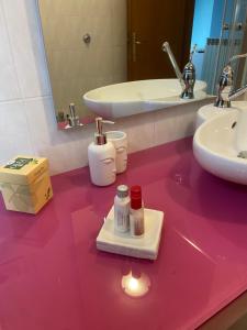 a bathroom with a pink counter with a sink and a mirror at La Casa del Borgo Antico in Campoverde +9 photos