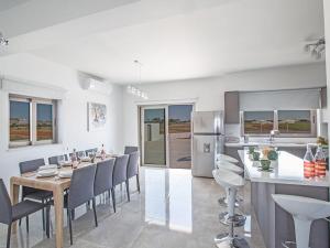 eine Küche und ein Esszimmer mit Tisch und Stühlen in der Unterkunft Villa Ioanni Chrysos - Luxury And New 6 Bedroom Protaras Villa in Protaras