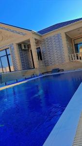 バクーにあるNovkhanı villaの家の前の青い大型スイミングプール