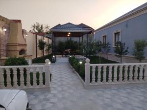 a house with a white fence and a gazebo at Novkhanı villa in Baku